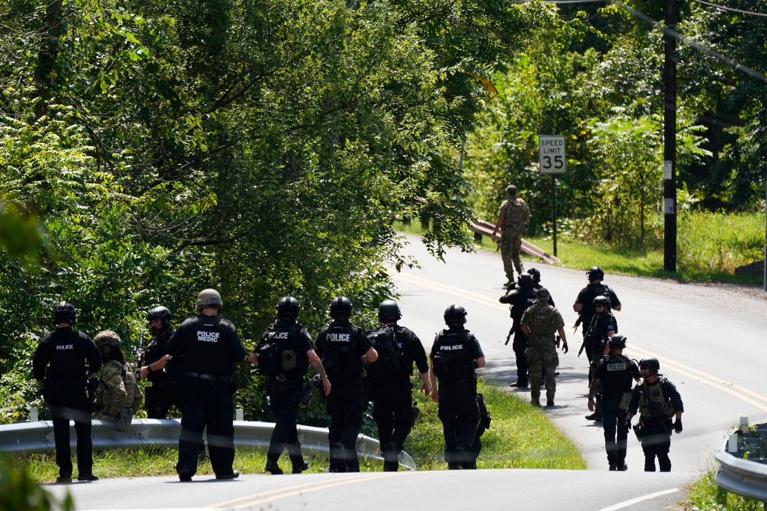 Law enforcement officers gather as the search for escaped convict Danelo Cavalcante continues Tuesday.