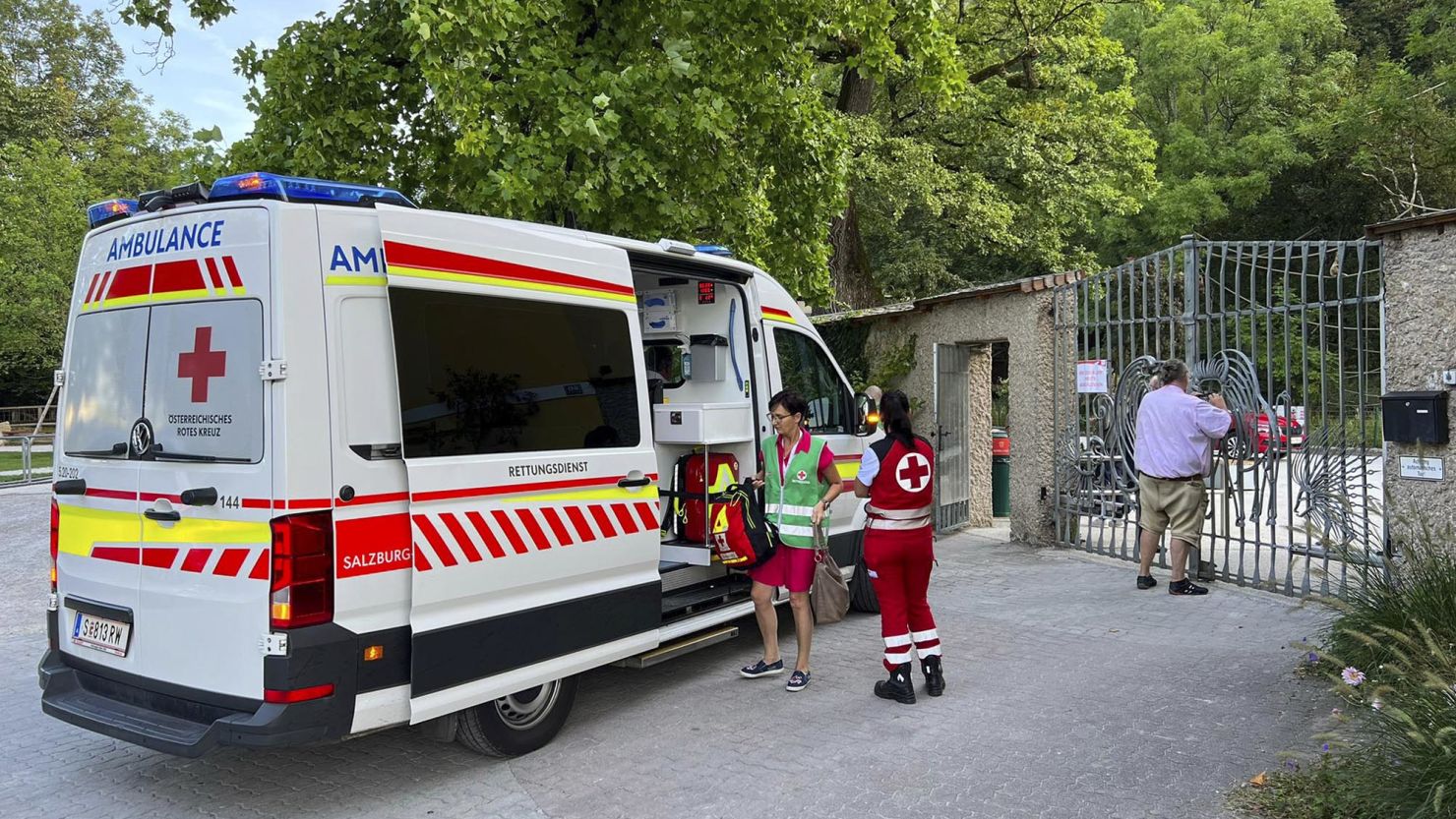 An ambulance with rescue helpers of the Red Cross stands at the entrance of the Salzburg Hellbrunn Zoo, in Austria, Tuesday, September. 12.