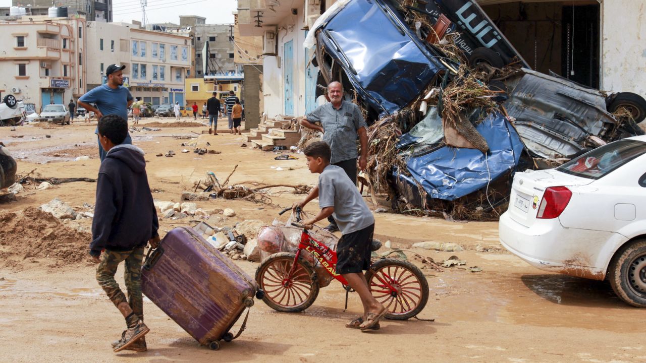 A boy pulls a suitcase past debris in a flash-flood damaged area in Derna, eastern Libya, on September 11, 2023.