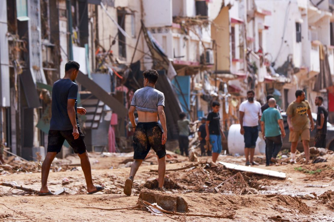 People inspect an area damaged by flash floods in Derna, in eastern Libya, on Monday.