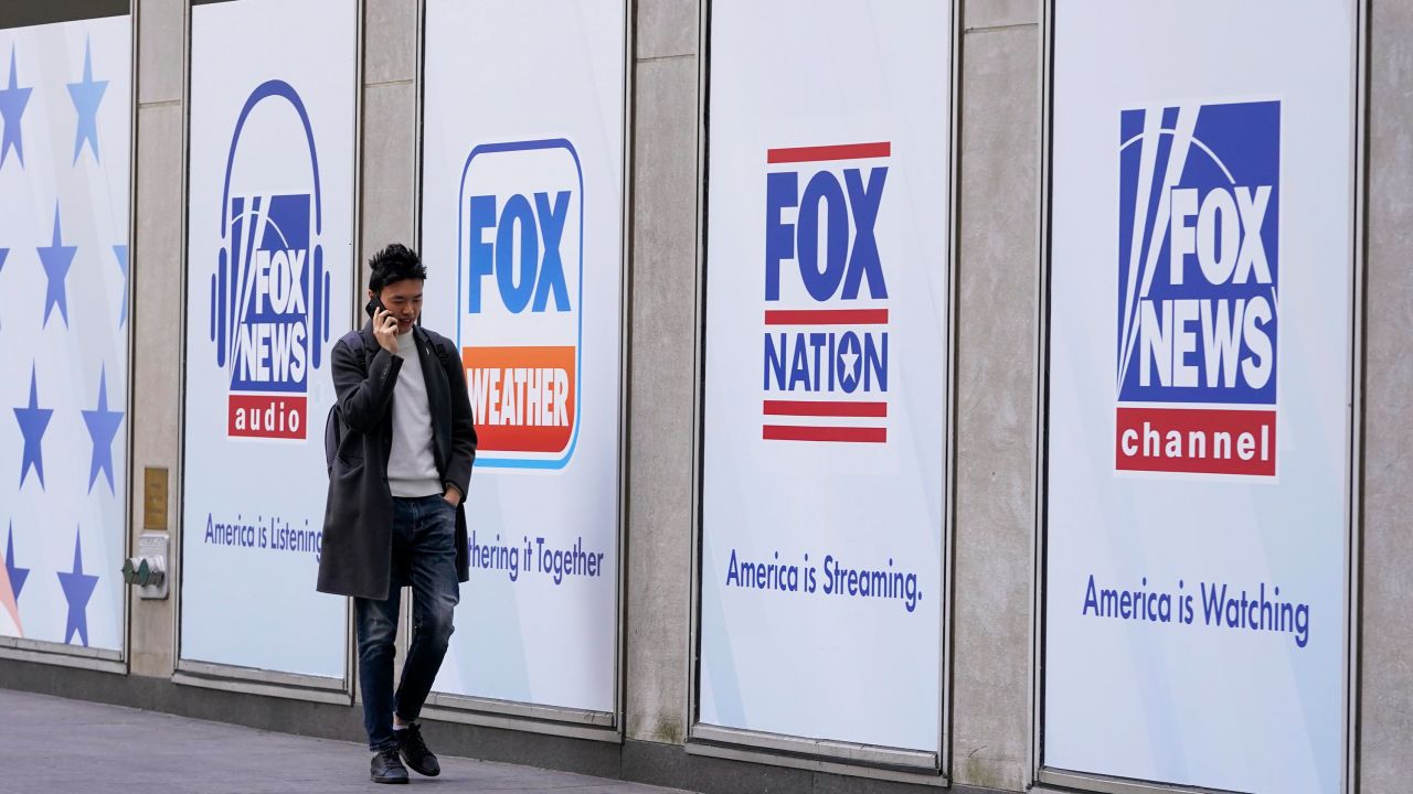 A man walks past the News Corp. Building and Fox News Headquarters, Wednesday, April 19, 2023, in New York.
