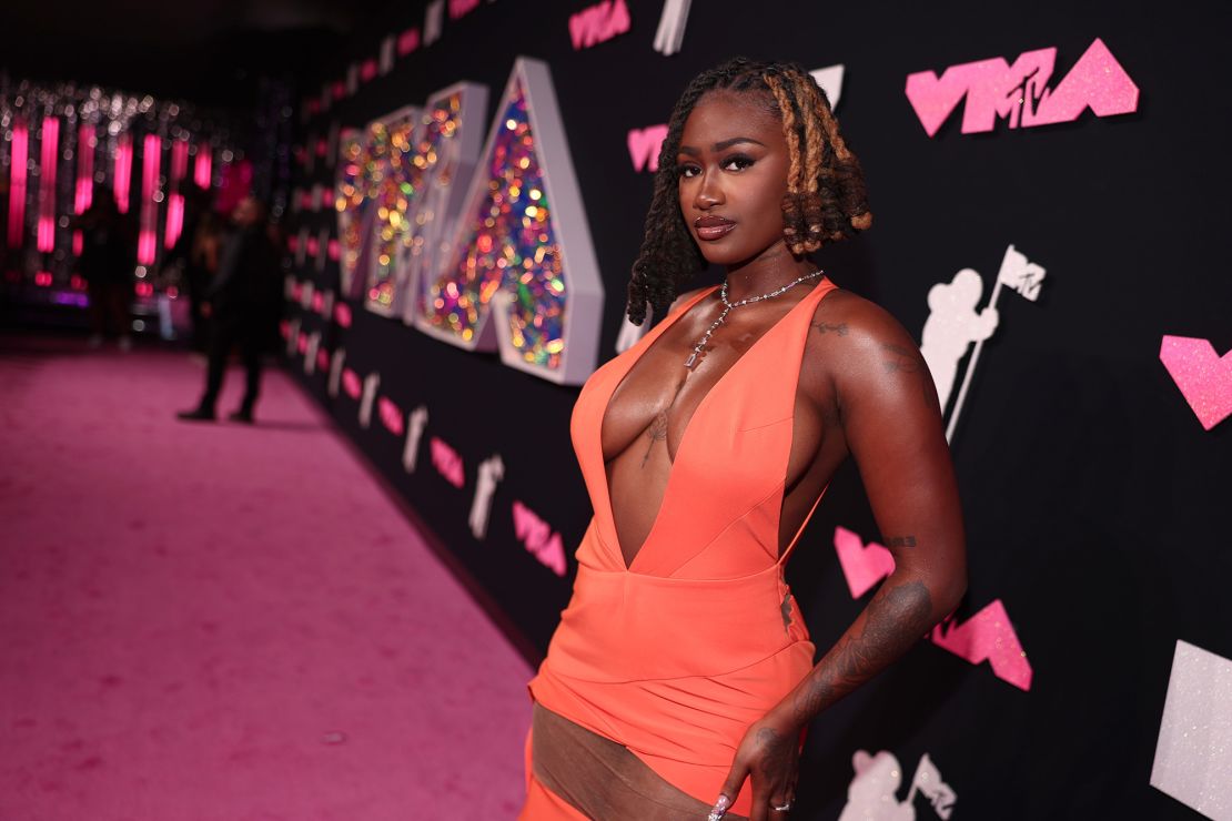 Rapper Kaliii offered a pop of color in a bright orange cut-out gown. 