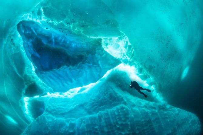 Franco Banfi took third place in the adventure category for this shot of a scuba diver exploring the underside of a gigantic iceberg in east Greenland.<br />