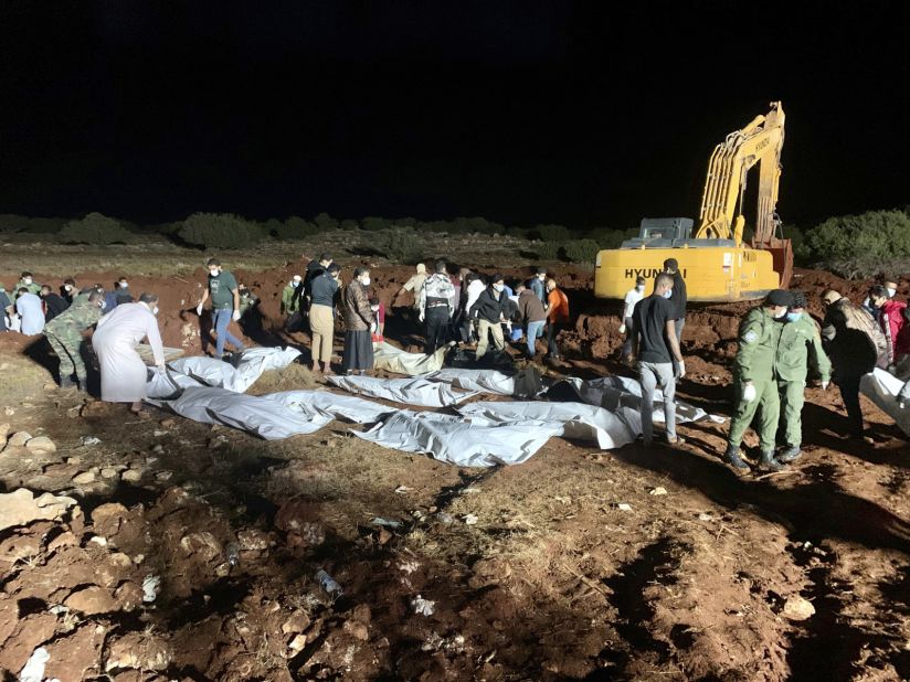 Workers bury the bodies of flood victims in Derna on September 13.