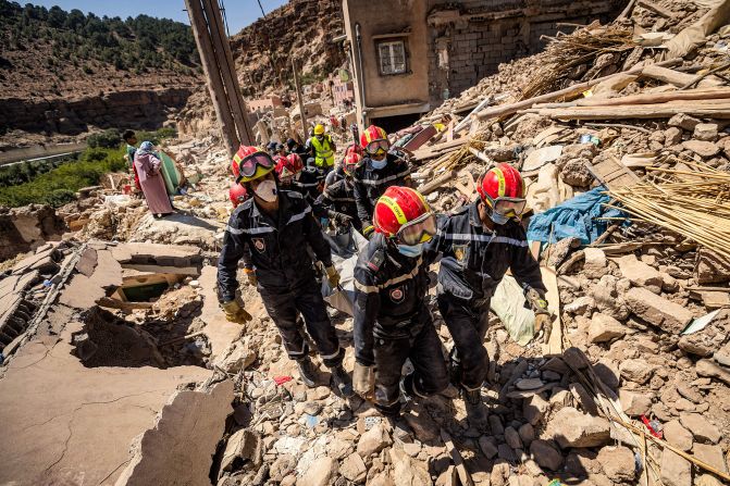 Rescue workers carry a body from a damaged house in Imi N'Tala, a village near Amizmiz, on September 13.