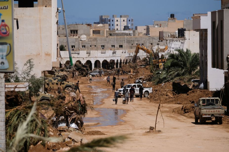 People walk between the rubble in Derna on September 13.