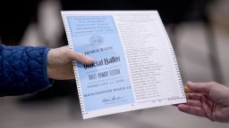 A woman takes a Democratic ballot to vote in the New Hampshire Primary at Parker-Varney Elementary School, Tuesday, Feb. 11, 2020, in Manchester, N.H. (AP Photo/Andrew Harnik)