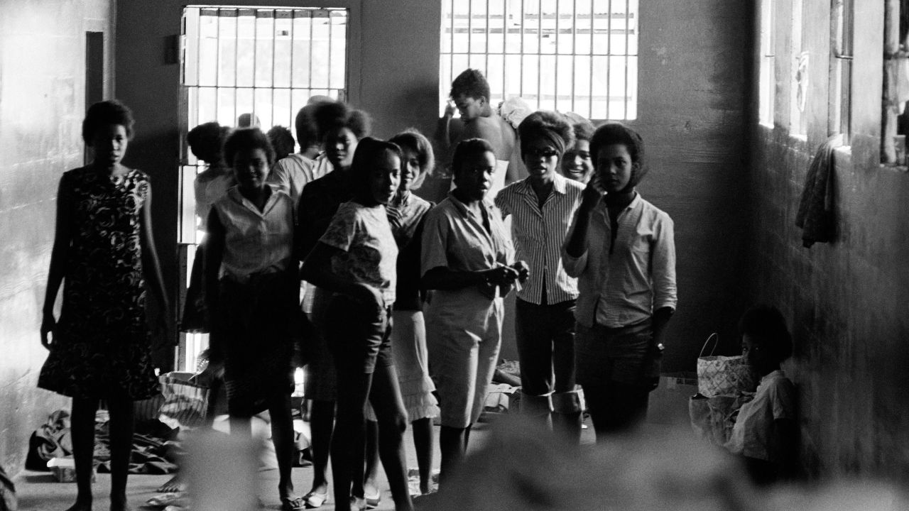 Teenage girls, including Shirley Reese who is holding onto the window bars, are held inside a stockade in Leesburg, Georgia, in 1963.