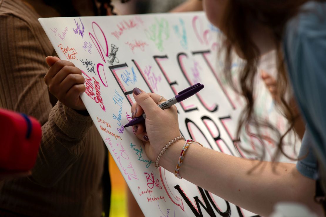 People sign a poster that reads "Elect More Women" during the Democratic rally in Glen Allen, Virginia, on September 9, 2023.