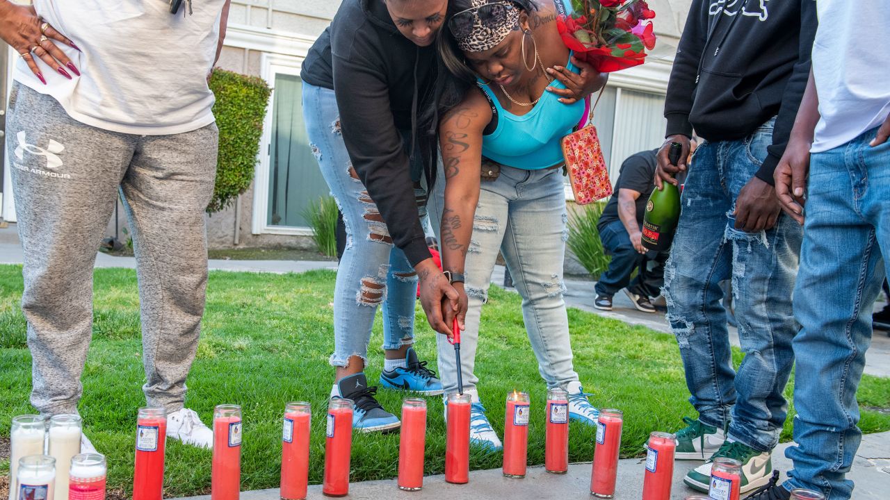 Angela Washington lights a candle for her son, Eric Gregory Brown III, during a vigil in Long Beach on May 10. 