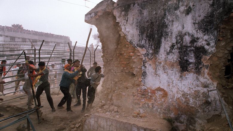 In this file photograph taken on December 6, 1992 Hindu fundamentalists attack the wall of the 16th century Babri Masjid Mosque with iron rods at a disputed holy site in the city of Ayodhya. Hindu nationalists believe that Babur's commander-in-chief Mir Baki destroyed an existing temple at the site, which Hindus believe was the temple built to commemorate the birthplace of Rama, an incarnation of Lord Vishnu and ruler of Ayodhya.  After 48 extensions and 399 hearings involving over 100 witnesses spread over nearly 17 years, Justice M S Liberhan on June 30, 2009 submitted his report on the demolition of Babri Masjid to Prime Minister Manmohan Singh. AFP PHOTO/DOUGLAS E CURRAN/FILES (Photo credit should read DOUGLAS E. CURRAN/AFP via Getty Images)