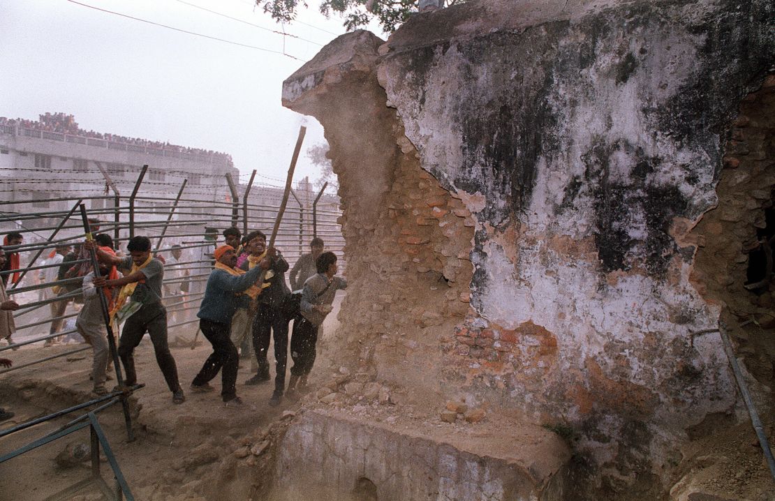 In this file photograph taken on December 6, 1992 Hindu fundamentalists attack the wall of the 16th century Babri Masjid Mosque with iron rods at a disputed holy site in the city of Ayodhya. Hindu nationalists believe that Babur's commander-in-chief Mir Baki destroyed an existing temple at the site, which Hindus believe was the temple built to commemorate the birthplace of Rama, an incarnation of Lord Vishnu and ruler of Ayodhya.  After 48 extensions and 399 hearings involving over 100 witnesses spread over nearly 17 years, Justice M S Liberhan on June 30, 2009 submitted his report on the demolition of Babri Masjid to Prime Minister Manmohan Singh. AFP PHOTO/DOUGLAS E CURRAN/FILES (Photo credit should read DOUGLAS E. CURRAN/AFP via Getty Images)