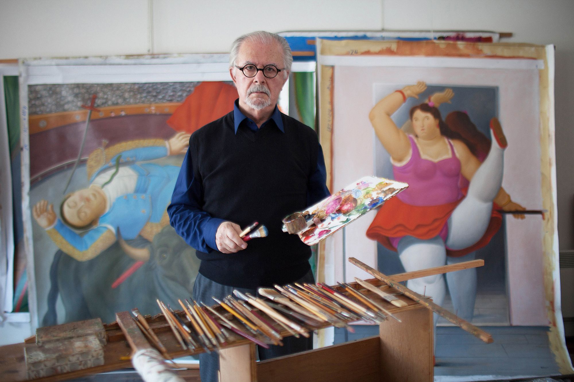 Colombian painter and sculptor Fernando Botero posing in his studio with paint brushes and palette in the hands. Behind him, a painting depicting a torero and another one portraying a dancer resting on the wall. Monte Carlo, 15th March 2012. (Photo by Massimo Sestini/Mondadori via Getty Images)