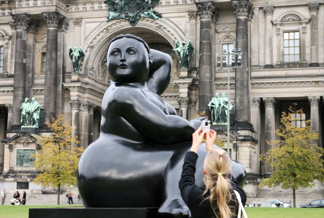 A woman takes pictures of Botero's 2002 sculpture "Seated Woman" on display in Berlin in October 2007.