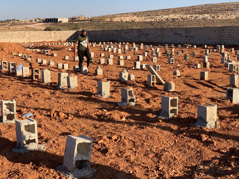 A man walks by the graves of flood victims in Derna on Friday, September 15.