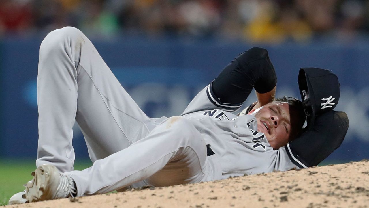 New York Yankees relief pitcher Anthony Misiewicz reacts after being hit in the head by a line drive off the bat of Pittsburgh Pirates second baseman Ji Hwan Bae.