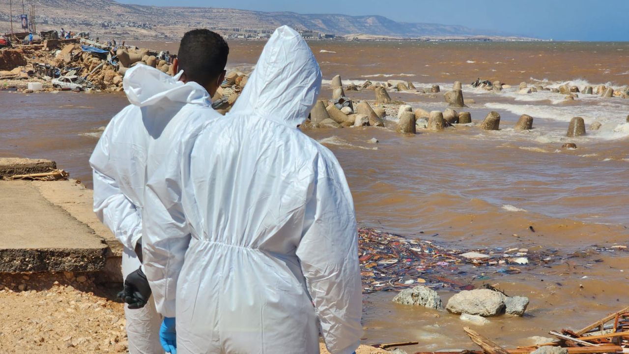 Volunteers in hazmat suits scan the sea for dead bodies in Derna.