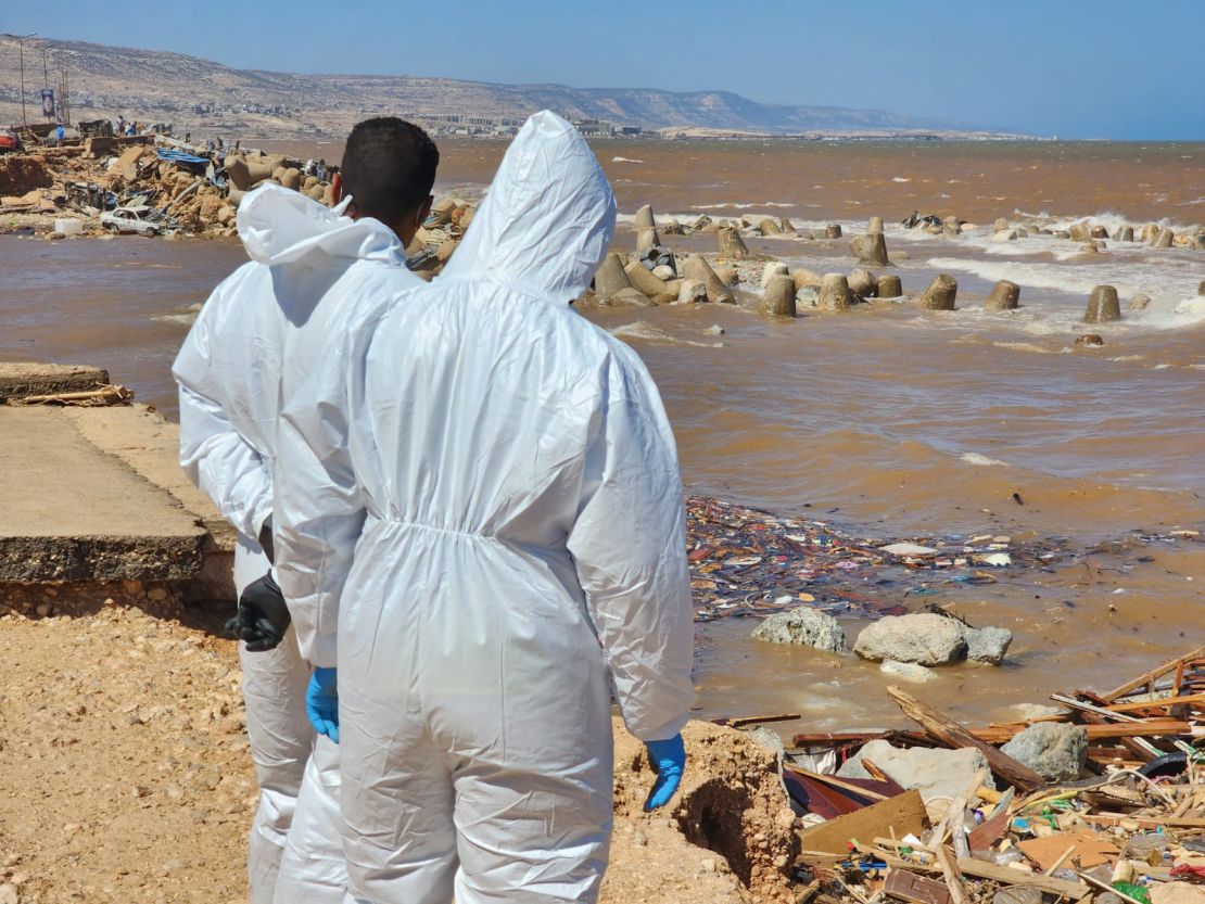 Volunteers in hazmat suits scan the sea for dead bodies in Derna.