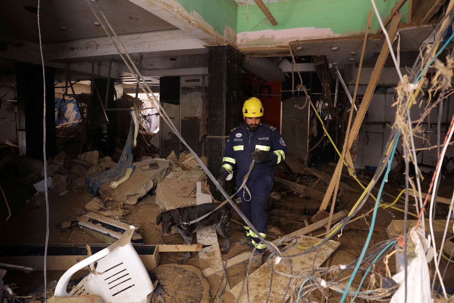 A rescuer from the United Arab Emirates uses a dog to look for human remains in Derna on Saturday, September 16.