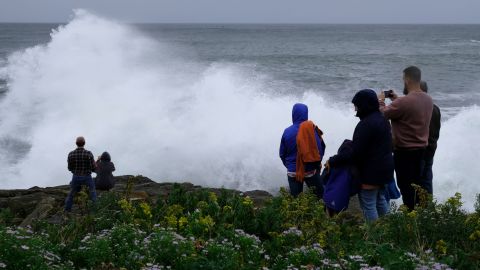 People watch rough surf and waves, remnants of Tropical Storm Lee, crash along the shore of Bailey Island, Maine, on Saturday, Sept 16, 2023. 