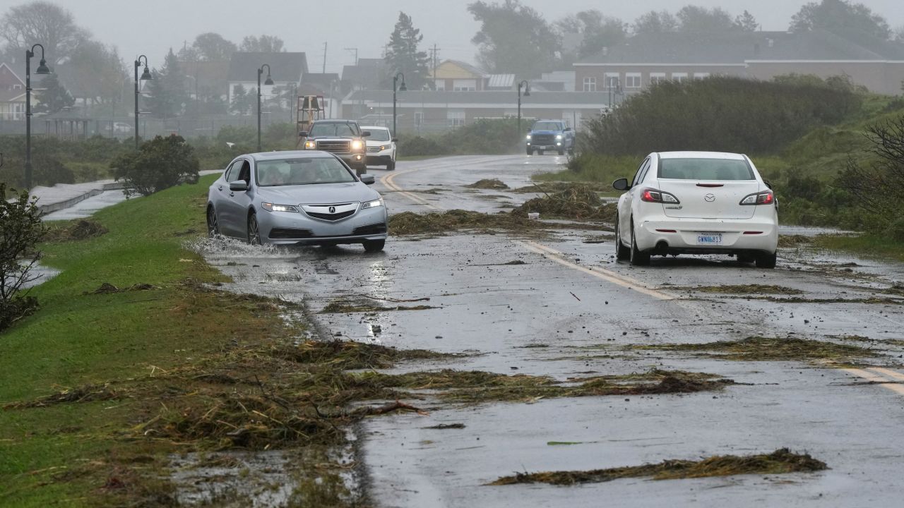 Vehicles navigate a debris-littered road in Lockeport, Nova Scotia, Canada, on Saturday.