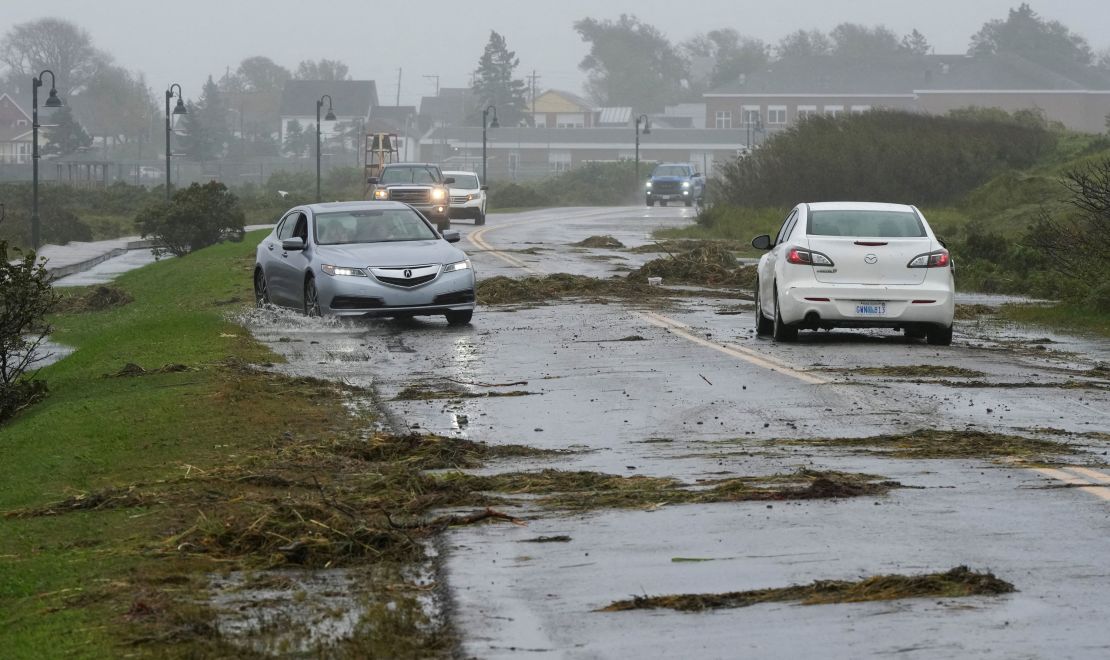 Vehicles navigate a debris-littered road in Lockeport, Nova Scotia, Canada, on Saturday.