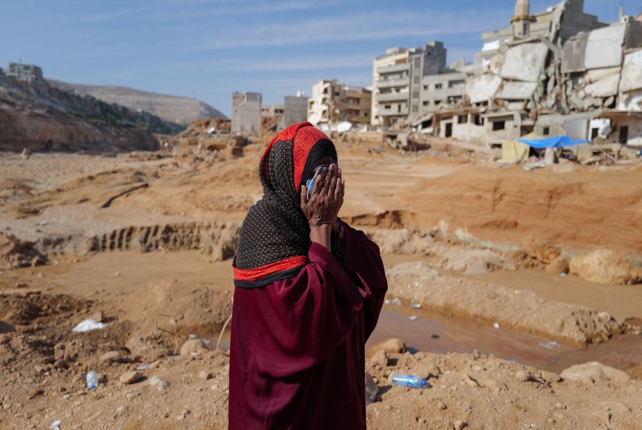 A woman who lost family members reacts as she walks past destroyed houses in Derna on September 17. 