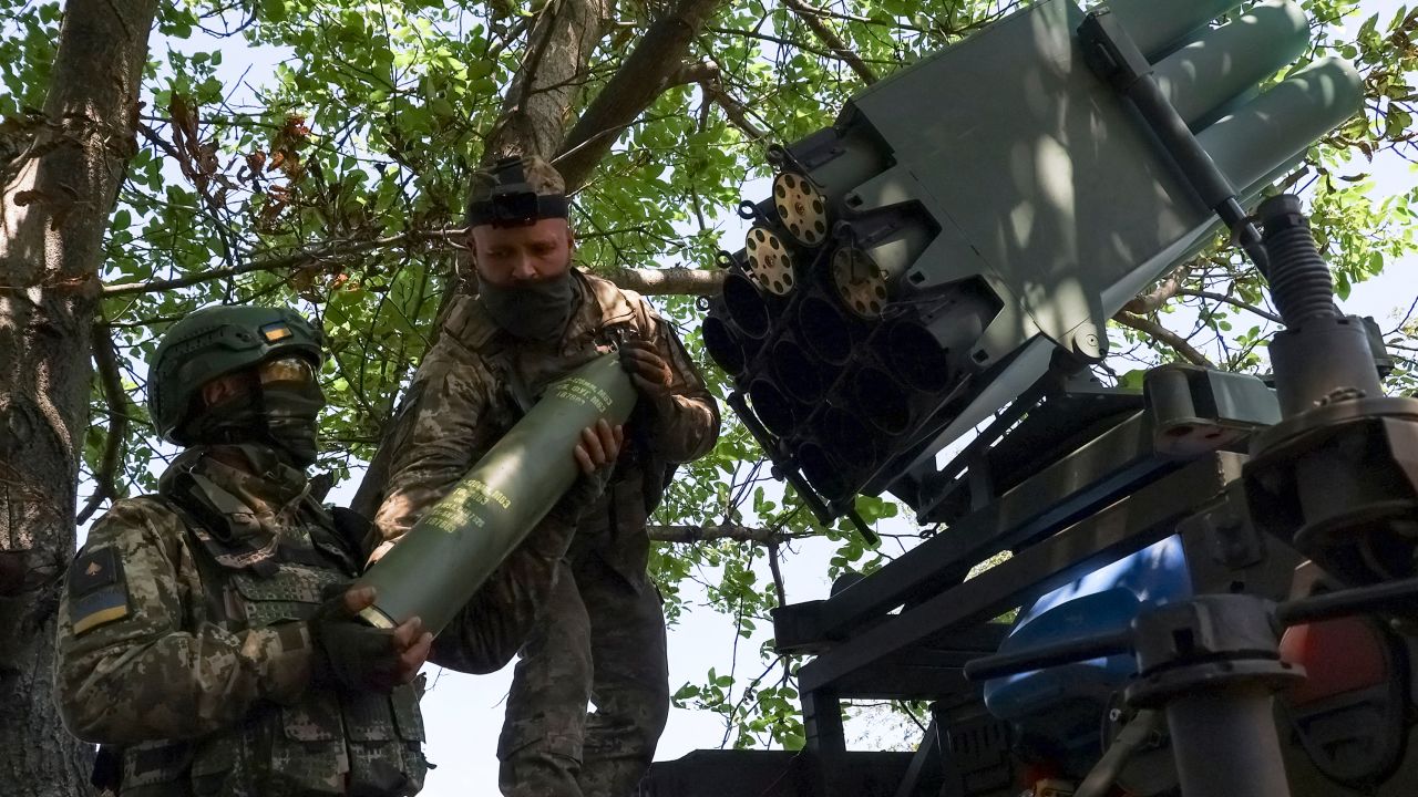 Ukrainian servicemen load shells into a RAK-SA-12 small multiple launch rocket system near the front line town of Bakhmut.