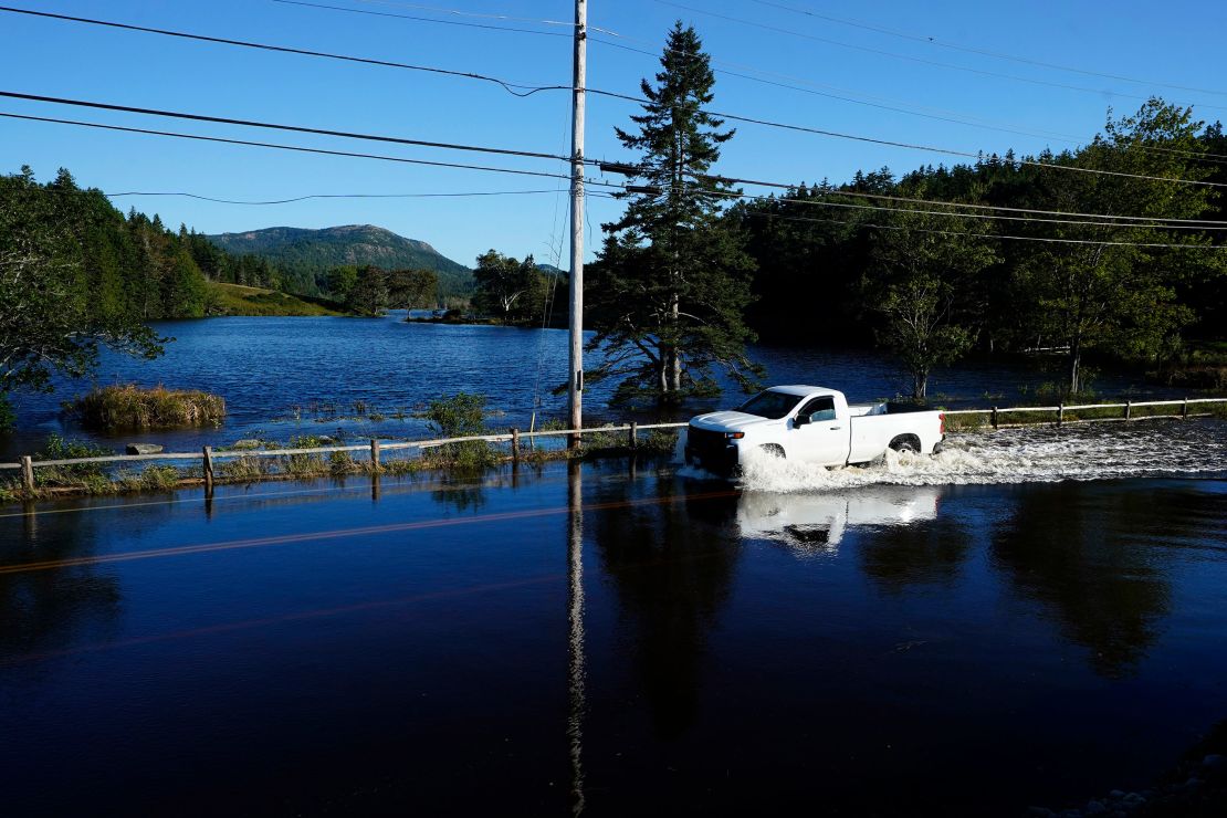 A motorist travels through flood waters near Northeast Harbor, Maine.