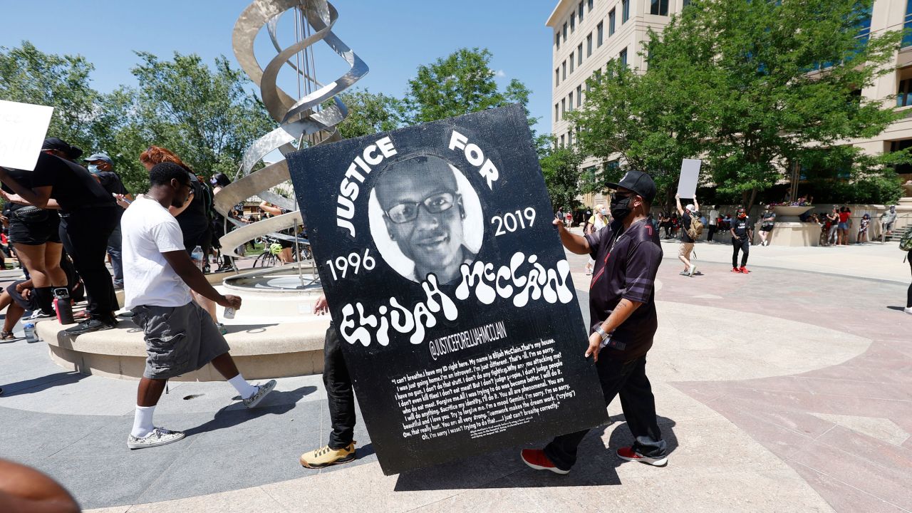 Demonstrators carried a giant placard during protests on June 27, 2020, outside the police department in Aurora.