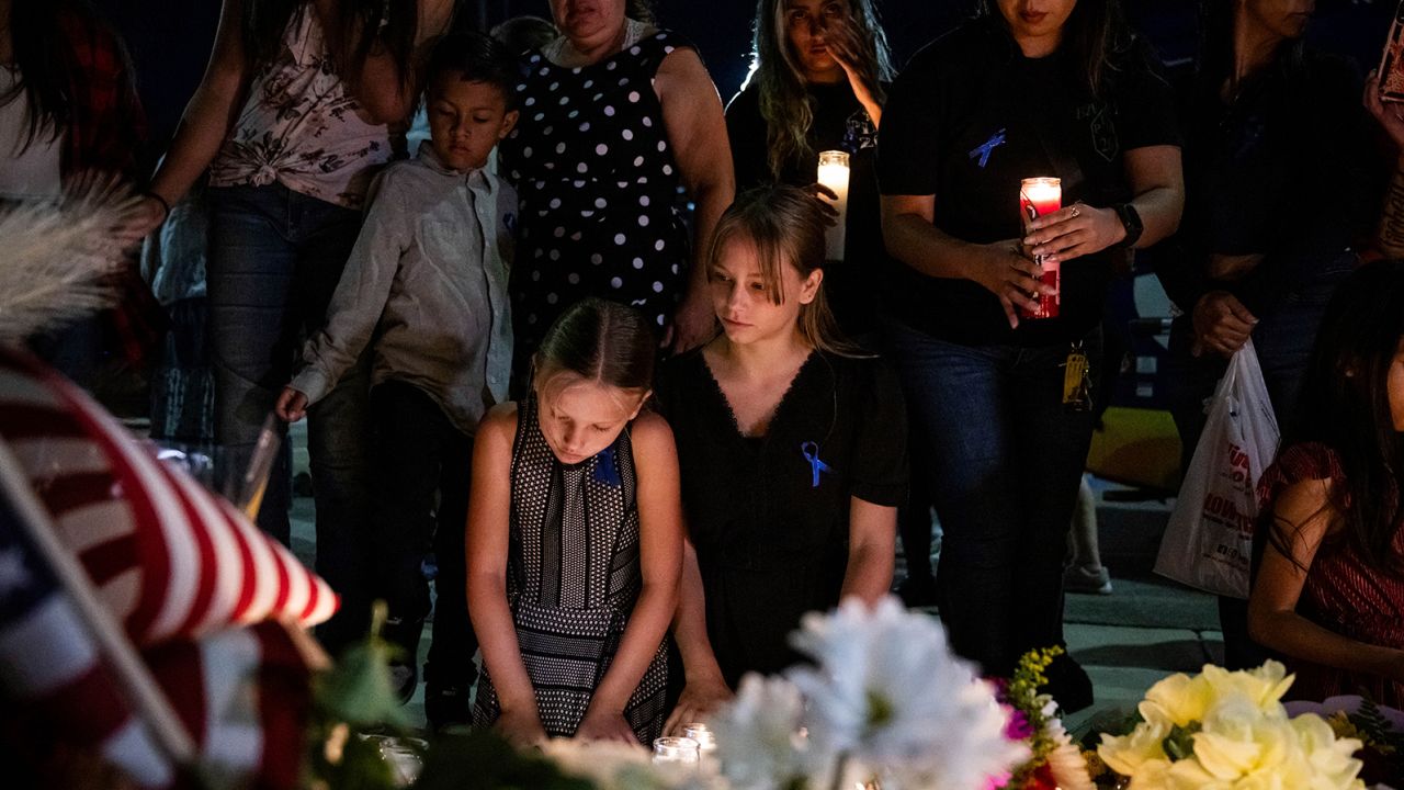 Mourners gather for a vigil Sunday in honor of Los Angeles County Sheriff's Deputy Ryan Clinkunbroomer at the Palmdale sheriff's station.