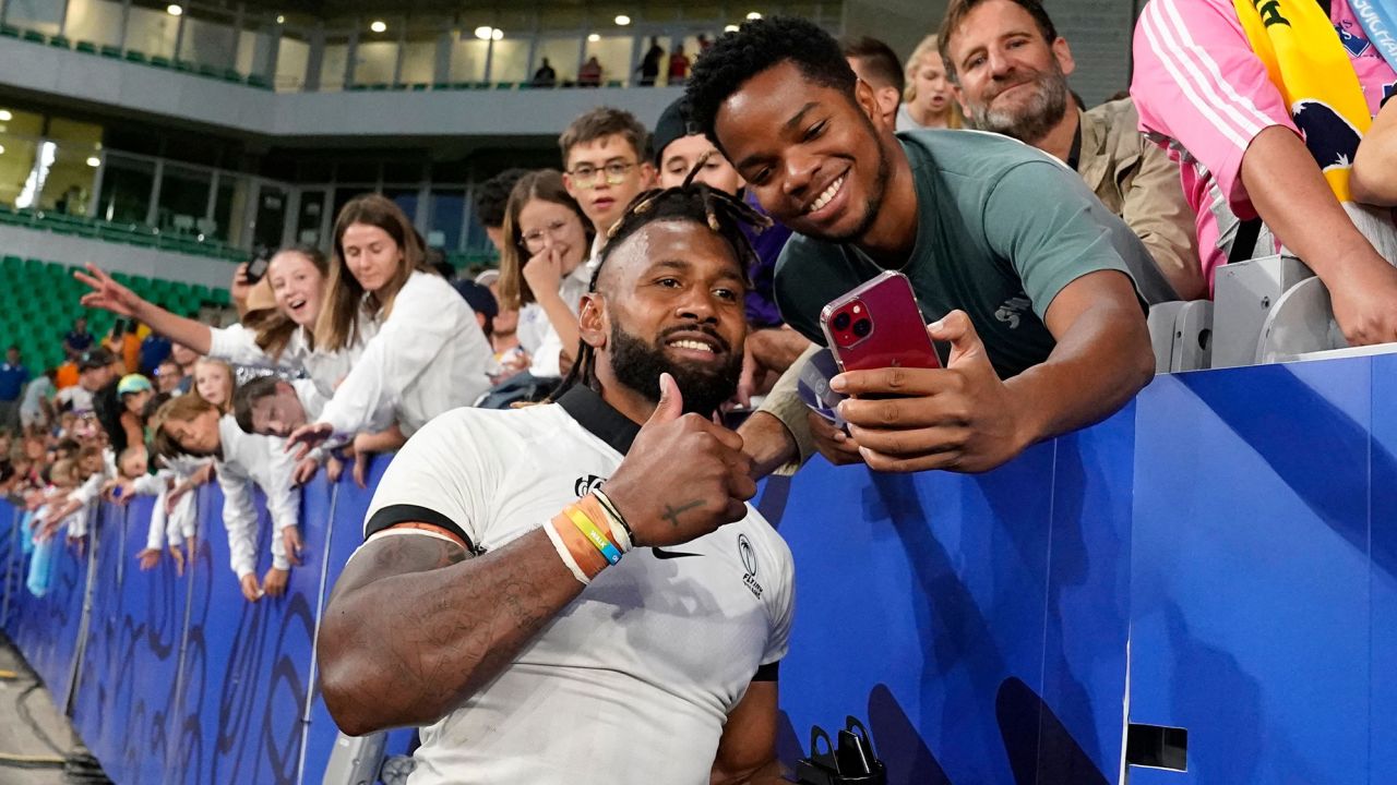 Fiji's outside centre and captain Waisea Nayacalevu (CL) takes a selfie with a fan as he celebrates Fiji's victory after the France 2023 Rugby World Cup Pool C match between Australia and Fiji at Stade Geoffroy-Guichard in Saint-Etienne, south-eastern France on September 17, 2023. (Photo by Francis BOMPARD / AFP) (Photo by FRANCIS BOMPARD/AFP via Getty Images)