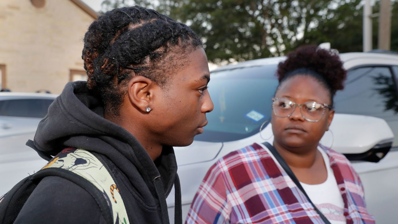 Darryl George, left, a 17-year-old junior, and his mother Darresha George, right, speak to reporters before school starts at Barbers Hill High School. 