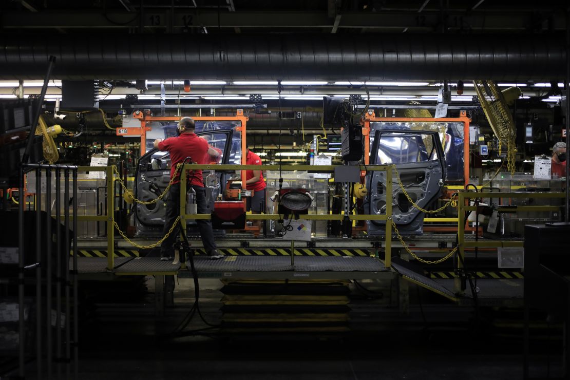 Workers install vehicle parts on an assembly line at the Nissan Motor Co. manufacturing facility in Smyrna, Tennessee, in May 2021. 