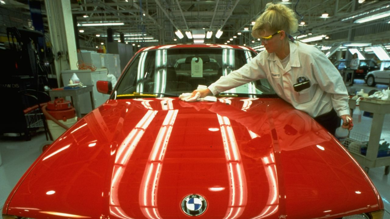 An auto worker inspecting finish of shiny red BMW at new American plant which can produce cars for much less than it costs in Germany. October 01, 1994