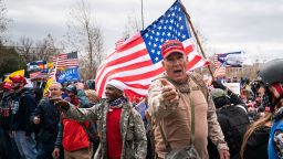 Ray Epps, in the red Trump hat, center, gestures to others as people gather on the West Front of the U.S. Capitol on Wednesday, Jan. 6, 2021 in Washington, DC. 