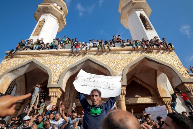 People gather for a demonstration outside the Al-Sahaba mosque in Derna, Libya, on Monday, September 18. <a href="index.php?page=&url=https%3A%2F%2Fwww.cnn.com%2F2023%2F09%2F19%2Fafrica%2Flibya-derna-flood-protests-intl%2Findex.html" target="_blank">The protesters are trying to hold leaders accountable</a> for the bursting of dams that some feel could have been avoided. This sign reads: "The sad city of Derna demands its rights."