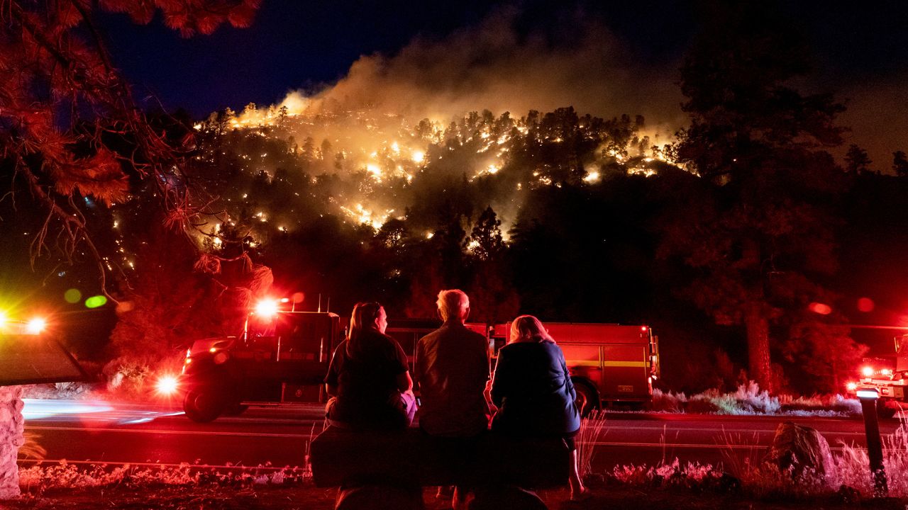 Los residentes observan parte del incendio Sheep que arde en una ladera cerca de sus casas en Wrightwood, California, el 11 de junio de 2022. 