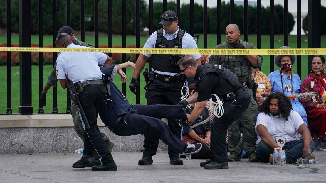 A demonstrator is detained and carried by members of the U.S. Secret Service and U.S. Park Police during an Indigenous Peoples' Day protest outside of the White House in Washington, U.S., October 11, 2021. REUTERS/Sarah Silbiger