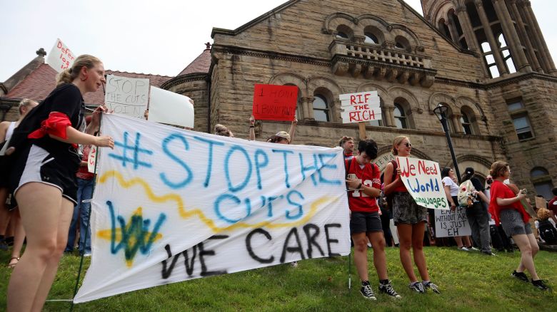 In this August 21 photo, West Virginia University students lead a protest against cuts to programs in world languages, creative writing and more amid a $45 million budget deficit outside Stewart Hall in Morgantown, West Virginia.