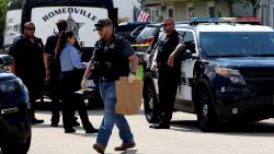 A Romeoville Police officer carries out a brown bagged marked with the words, "Drywall from hallway" from inside of the home where four people were shot to death on Monday, Sept. 18, 2023, in Romeoville Ill. (Stacey Wescott/Chicago Tribune via AP)