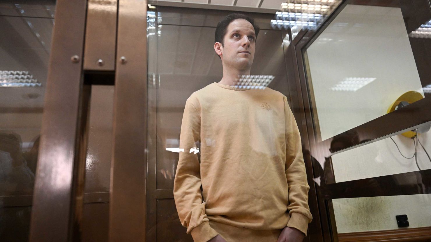 Evan Gershkovich stands inside a defendants' cage before a hearing in Moscow on Tuesday.