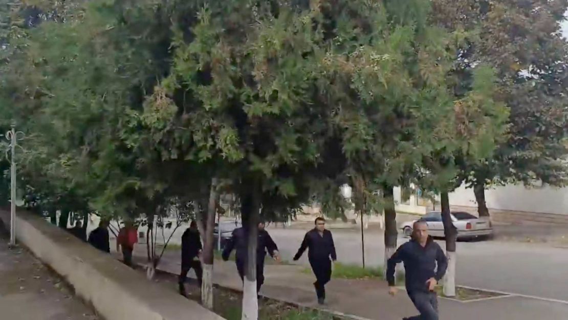 People run as gunfire and explosions are heard in Stepanakert, in the Nagorno-Karabakh region, in this screengrab obtained from a handout video.