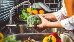 Hand of maid washing tomato fresh vegetables preparation healthy food in kitchen