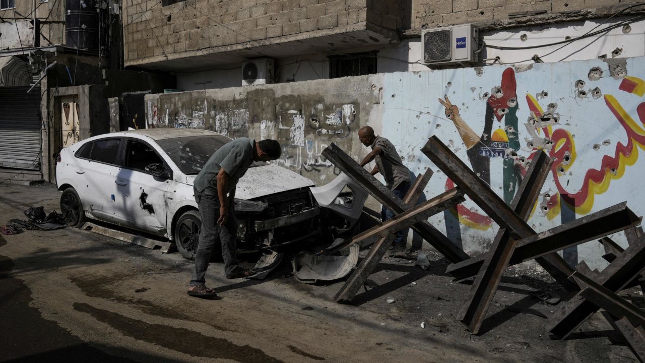 Palestinians, pictured on Wednesday, inspect a car that was damaged after an Israeli military raid in the occupied West Bank, on September 19.