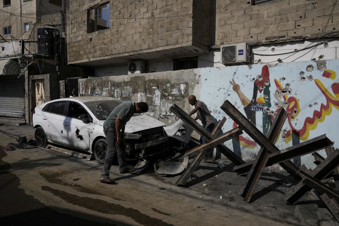 Palestinians, pictured on Wednesday, inspect a car that was damaged after an Israeli military raid in the occupied West Bank, on September 19.