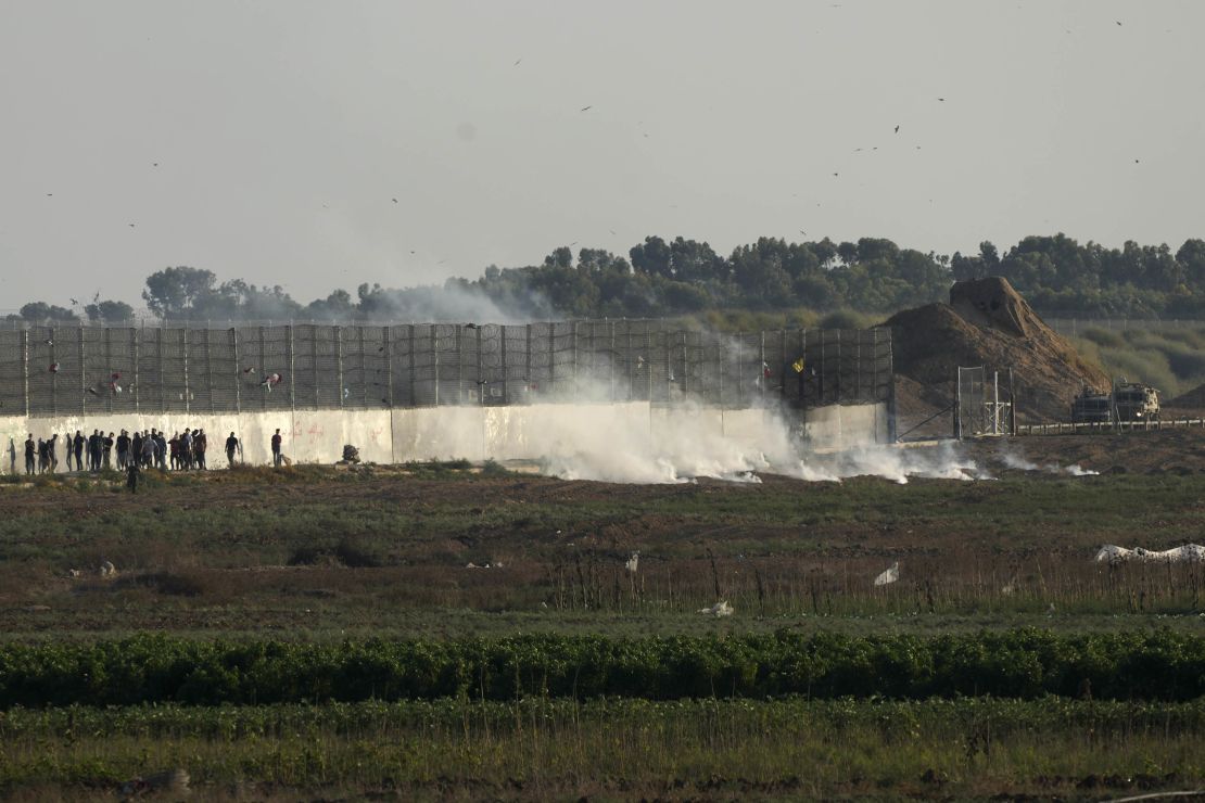 Palestinian protesters run from teargas, as Israeli security forces crack down on protests along the Gaza border fence. 