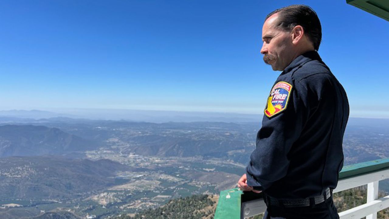 El jefe de personal de inteligencia de incendios de Cal Fire, Phillip SeLegue, se encuentra en una torre de vigilancia en el condado de San Diego.  Dice que la IA no reemplazará las torres, pero mejorará los esfuerzos de extinción de incendios.