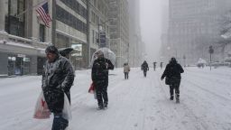 People walk on snow as a winter storm hits New York City on January 23, 2016.