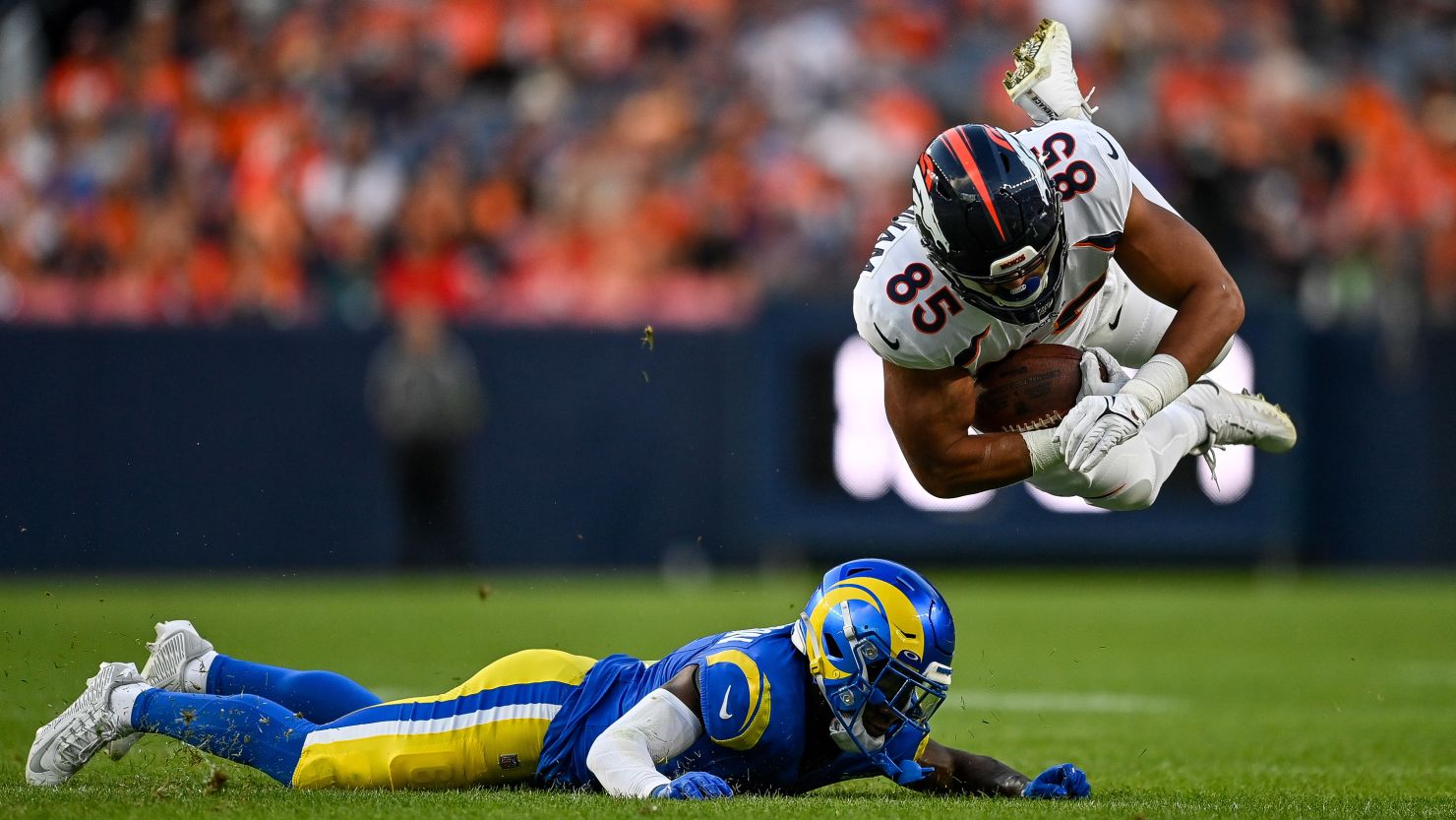 Tight end Albert Okwuegbunam #85 of the Denver Broncos is tackled by cornerback Tre Tomlinson #6 of the Los Angeles Rams in the first quarter of a preseason game at Empower Field at Mile High on August 26, 2023 in Denver, Colorado.